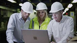factory staff observing alarm notification on laptop